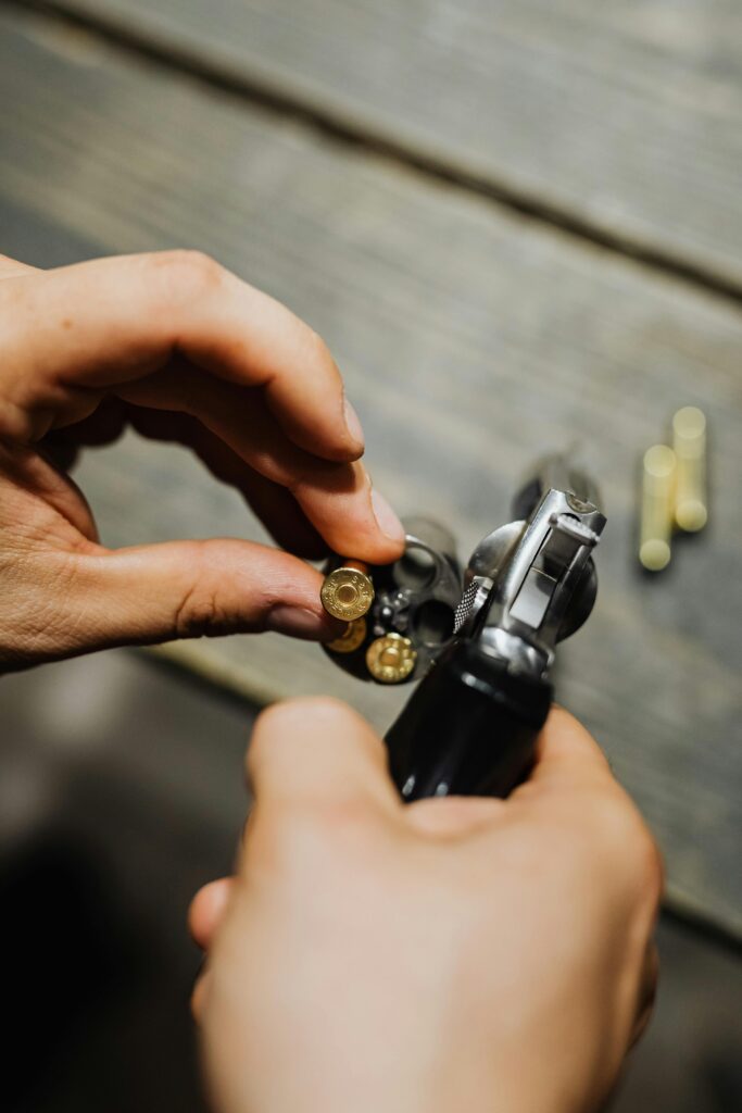 someone putting ammo into the barrel of a handgun