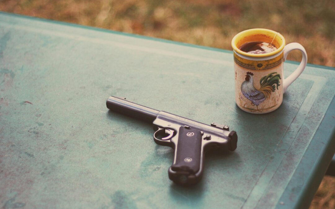 a gun on a table next to coffee